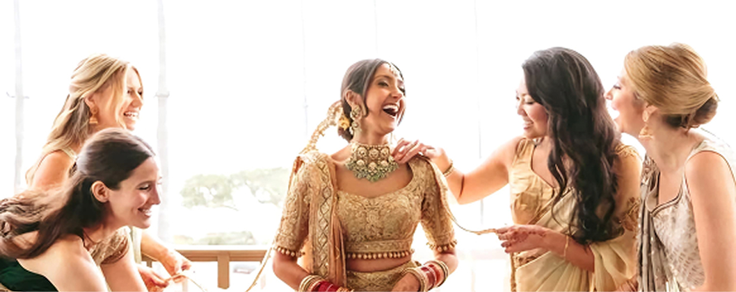 Bride laughing with bridesmaids wearing jewellery